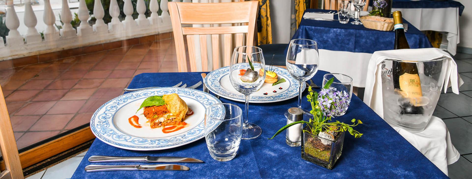 Elegante tavolo da ristorante con vista, piatti raffinati e vino in fresco.