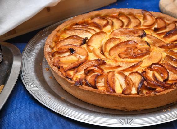 Deliziosa crostata di mele dorate, profumata e invitante, su un elegante piatto argentato.