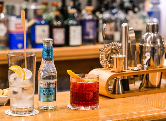Cocktail colorati, strumenti da bar eleganti, atmosfera vivace e sofisticata in un bar accogliente.