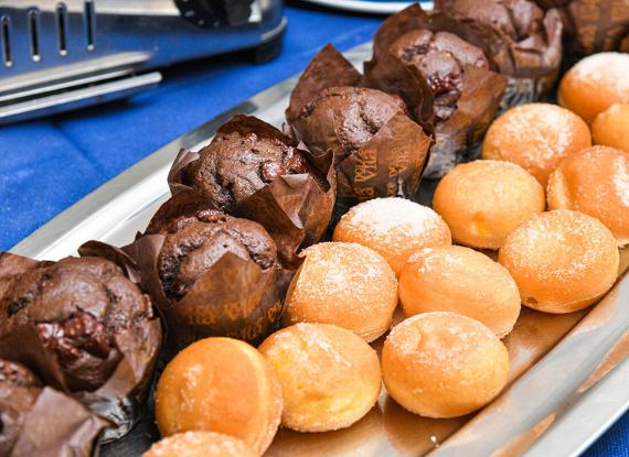 Vassoio con muffin al cioccolato e soffici bomboloni zuccherati, invitanti e golosi.