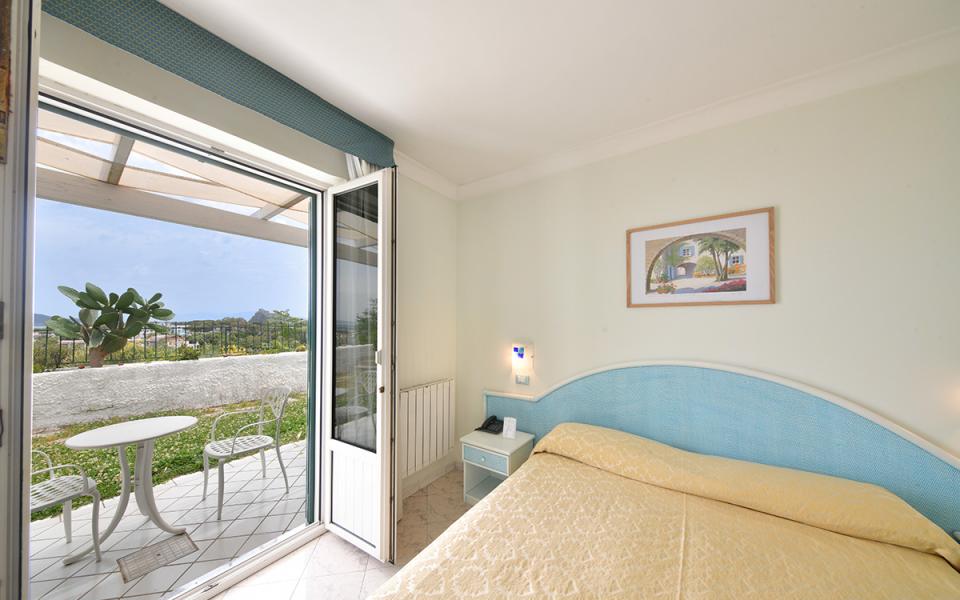 Camera luminosa con vista giardino, letto accogliente e atmosfera tranquilla e rilassante.